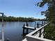 Scenic view of a serene canal with wooden docks and lush green vegetation under a clear blue sky at 107 Jose Gaspar Dr, Englewood, FL 34223
