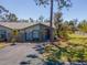 View of a well-maintained townhome with mature trees and front yard at 107 Jose Gaspar Dr, Englewood, FL 34223