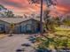 Charming one-story home featuring a well-manicured lawn and a paved driveway against a vibrant sunset backdrop at 107 Jose Gaspar Dr, Englewood, FL 34223