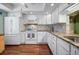 Bright kitchen with white cabinets, granite countertops, stainless steel appliances, and wood-look flooring at 107 Jose Gaspar Dr, Englewood, FL 34223