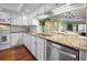 Well-equipped kitchen with stainless steel dishwasher, granite counters, and a pass-through to the dining area at 107 Jose Gaspar Dr, Englewood, FL 34223