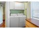 Functional laundry room featuring a washer, dryer, storage cabinets, and a window for natural light at 107 Jose Gaspar Dr, Englewood, FL 34223