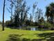 Picturesque pond with a fountain, surrounded by vibrant green lawns and native trees with birds at 107 Jose Gaspar Dr, Englewood, FL 34223