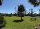 Landscaped green lawn featuring a picturesque pond, a fountain, and a cozy park bench under the sky at 107 Jose Gaspar Dr, Englewood, FL 34223