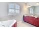 A modern bathroom with a soaking tub, double sinks, and custom wood cabinets at 12605 Bacchus Rd, Port Charlotte, FL 33981