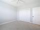 Spacious bedroom with neutral carpet, ceiling fan, and closet with bi-fold doors at 12605 Bacchus Rd, Port Charlotte, FL 33981