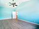 A spacious bedroom with a ceiling fan, bright teal walls, and wood-look tile at 12605 Bacchus Rd, Port Charlotte, FL 33981