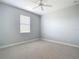 Vacant bedroom boasts neutral carpet, light gray walls, and a window at 12605 Bacchus Rd, Port Charlotte, FL 33981