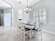 Dining room with wainscoting, a chandelier, and a white table and chairs at 12605 Bacchus Rd, Port Charlotte, FL 33981