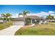 Charming single-story home with a well-manicured lawn and mature palm trees at 12605 Bacchus Rd, Port Charlotte, FL 33981