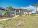 Home with an arched entryway, lush lawn and mature landscaping, showcasing curb appeal at 12605 Bacchus Rd, Port Charlotte, FL 33981