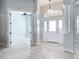 Bright foyer with white tile floors, columns, and an arched transom window over the front door at 12605 Bacchus Rd, Port Charlotte, FL 33981