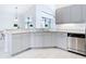 Well-lit kitchen with gray cabinets, tile backsplash, granite counters and stainless steel appliances at 12605 Bacchus Rd, Port Charlotte, FL 33981