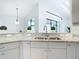 Bright kitchen with light cabinets, granite countertops, stainless steel sink and tile floors at 12605 Bacchus Rd, Port Charlotte, FL 33981