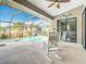 Covered lanai featuring white rocking chairs, ceiling fan, and views of the pool and spa at 12605 Bacchus Rd, Port Charlotte, FL 33981