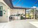 Outdoor kitchen under screened lanai featuring a sink, mini fridge, bar seating and decor at 12605 Bacchus Rd, Port Charlotte, FL 33981