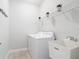Bright laundry room features white appliances, a utility sink, and wire rack shelving at 12605 Bacchus Rd, Port Charlotte, FL 33981