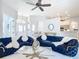 Spacious living room features two blue couches, ceiling fan, and view to dining area at 12605 Bacchus Rd, Port Charlotte, FL 33981