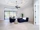Open-concept living room with tray ceiling, a ceiling fan, and sliding doors to lanai at 12605 Bacchus Rd, Port Charlotte, FL 33981