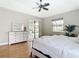 The main bedroom has wood flooring, a ceiling fan, and sliding door access to the lanai at 12605 Bacchus Rd, Port Charlotte, FL 33981