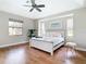 The main bedroom has wood flooring, a ceiling fan, and large windows for natural light at 12605 Bacchus Rd, Port Charlotte, FL 33981