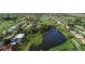 Picturesque aerial view of homes surrounding a lake and golf course with lush green grass at 13 Caddy Rd, Rotonda West, FL 33947