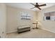 A simple bedroom features a ceiling fan, carpeted floors, and neutral colors with a window for natural light at 13 Caddy Rd, Rotonda West, FL 33947