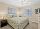 A serene bedroom features soft lighting, two windows, and calm neutral colors at 13 Caddy Rd, Rotonda West, FL 33947