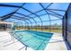 Indoor swimming pool featuring a screened enclosure and a pristine backyard at 13 Caddy Rd, Rotonda West, FL 33947