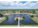 High aerial view of waterfront homes with boat docks and a charming small island, perfect for waterfront living at 13 Caddy Rd, Rotonda West, FL 33947