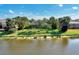 Aerial view of home featuring a beautiful lake, well-maintained lawn and tropical landscaping at 14236 Silver Lakes Cir, Port Charlotte, FL 33953