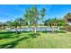 Beautiful backyard view with lush green grass and palm trees overlooking the serene water at 14236 Silver Lakes Cir, Port Charlotte, FL 33953