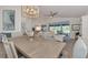 Dining room features light wood table, chandelier, beach painting, and open floor plan at 14236 Silver Lakes Cir, Port Charlotte, FL 33953