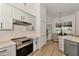 Kitchen features light gray cabinets, stainless steel appliances, and light wood floor at 14236 Silver Lakes Cir, Port Charlotte, FL 33953