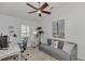 Bright office features a ceiling fan, a comfortable couch, and a work area with a computer for a productive atmosphere at 14236 Silver Lakes Cir, Port Charlotte, FL 33953