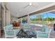 Spacious patio features comfortable seating, a dining table, and stunning views of the screened-in pool and lake at 14236 Silver Lakes Cir, Port Charlotte, FL 33953