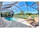 Inviting screened-in pool area features lounge chairs and scenic lake views, offering a relaxing outdoor experience at 14236 Silver Lakes Cir, Port Charlotte, FL 33953