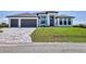 Modern home features a three-car garage, manicured lawn, and stylish exterior design at 14246 Maysville, Port Charlotte, FL 33981