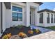 Close-up of a modern home's front entrance with stylish landscaping and an ADT security sign at 14246 Maysville, Port Charlotte, FL 33981