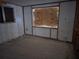 Bedroom under renovation features boarded windows, unfinished walls, and a plain concrete floor at 1432 Lemon Bay Dr, Englewood, FL 34223