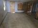 An unfinished room under construction, featuring concrete floor, plywood covered window, and exposed framing at 1432 Lemon Bay Dr, Englewood, FL 34223