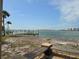 Scenic waterfront view featuring a dock, a glimpse of the bay, and neighboring buildings in the distance at 1432 Lemon Bay Dr, Englewood, FL 34223