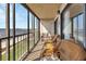 Relaxing enclosed balcony featuring wicker furniture and picturesque waterfront views at 14459 River Beach Dr # 129, Port Charlotte, FL 33953
