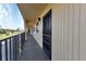 Condo with exterior hallway showcasing neutral colors, and a sleek black door at 14459 River Beach Dr # 129, Port Charlotte, FL 33953