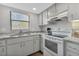 Bright kitchen with white appliances, marble countertops, and a stainless steel faucet at 14459 River Beach Dr # 129, Port Charlotte, FL 33953