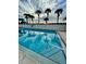Community pool with surrounding palm trees and lounge chairs offers residents relaxation at 14459 River Beach Dr # 129, Port Charlotte, FL 33953