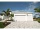 Bright white modern home features a three-car garage with paved driveway at 15342 Aron, Port Charlotte, FL 33981
