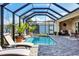 Inviting screened-in pool area with lush landscaping and sun loungers for relaxing at 15342 Aron, Port Charlotte, FL 33981