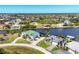 Scenic aerial view of waterfront homes with private docks on a wide canal and palm trees at 15498 Seafoam Cir, Port Charlotte, FL 33981