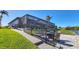Beautiful backyard with seating area, lush green lawn, and peaceful water views at 15498 Seafoam Cir, Port Charlotte, FL 33981